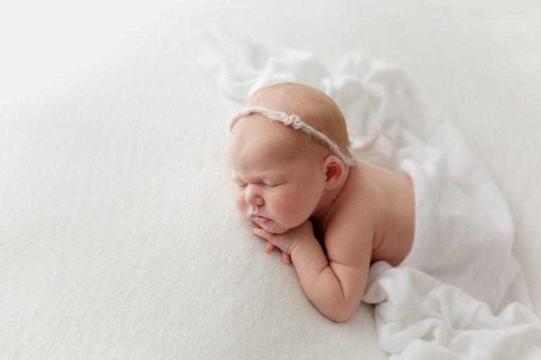 Baby laying on white blanket