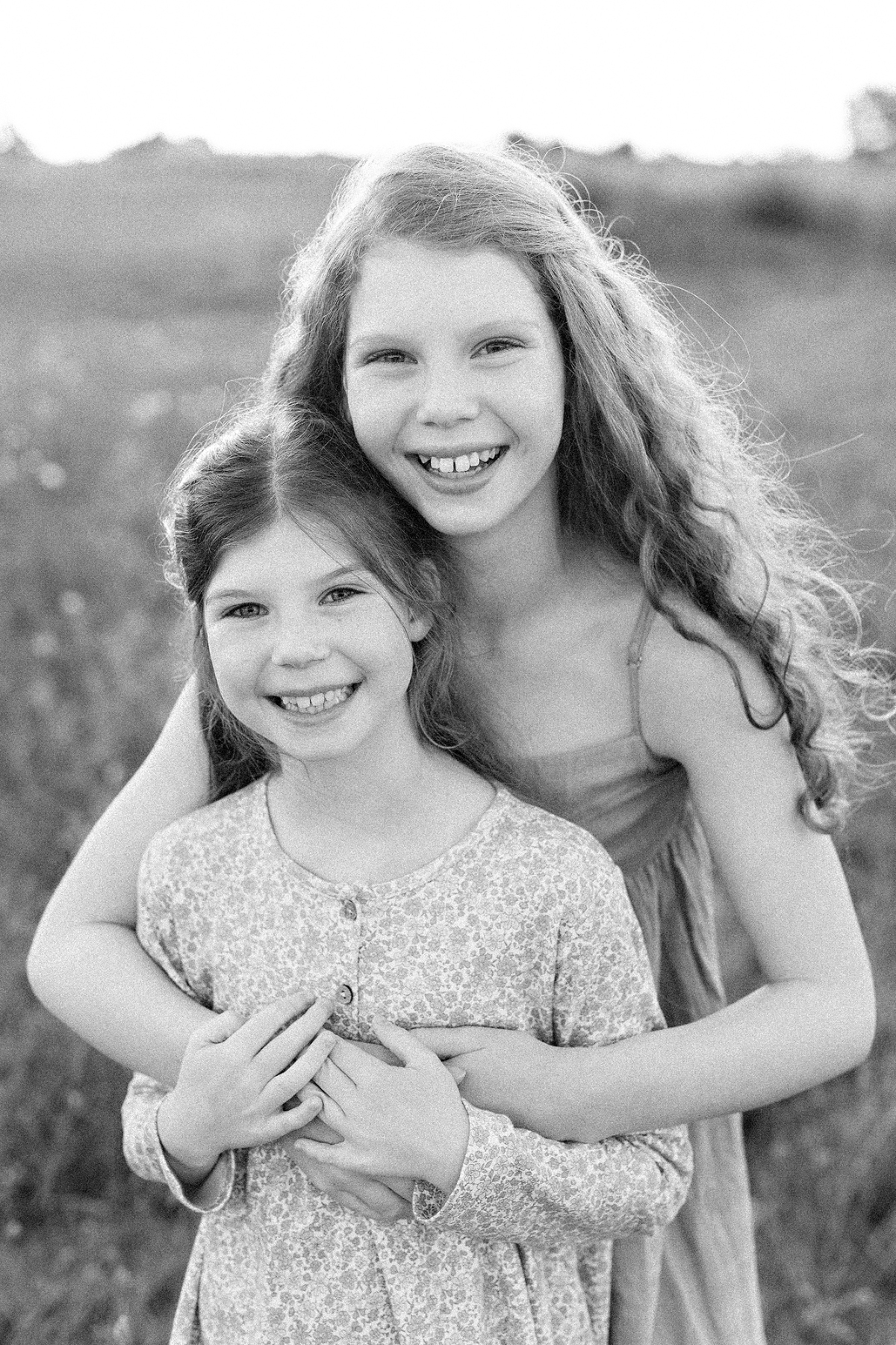 sister hugging and smiling at the camera