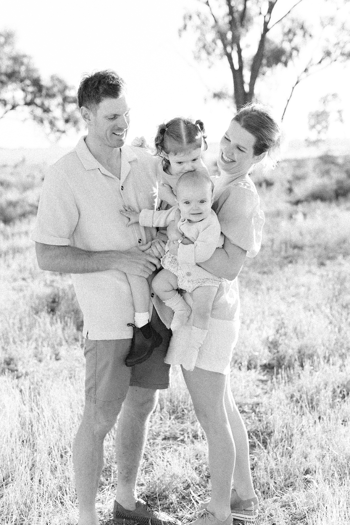 family standing in a paddock laughing