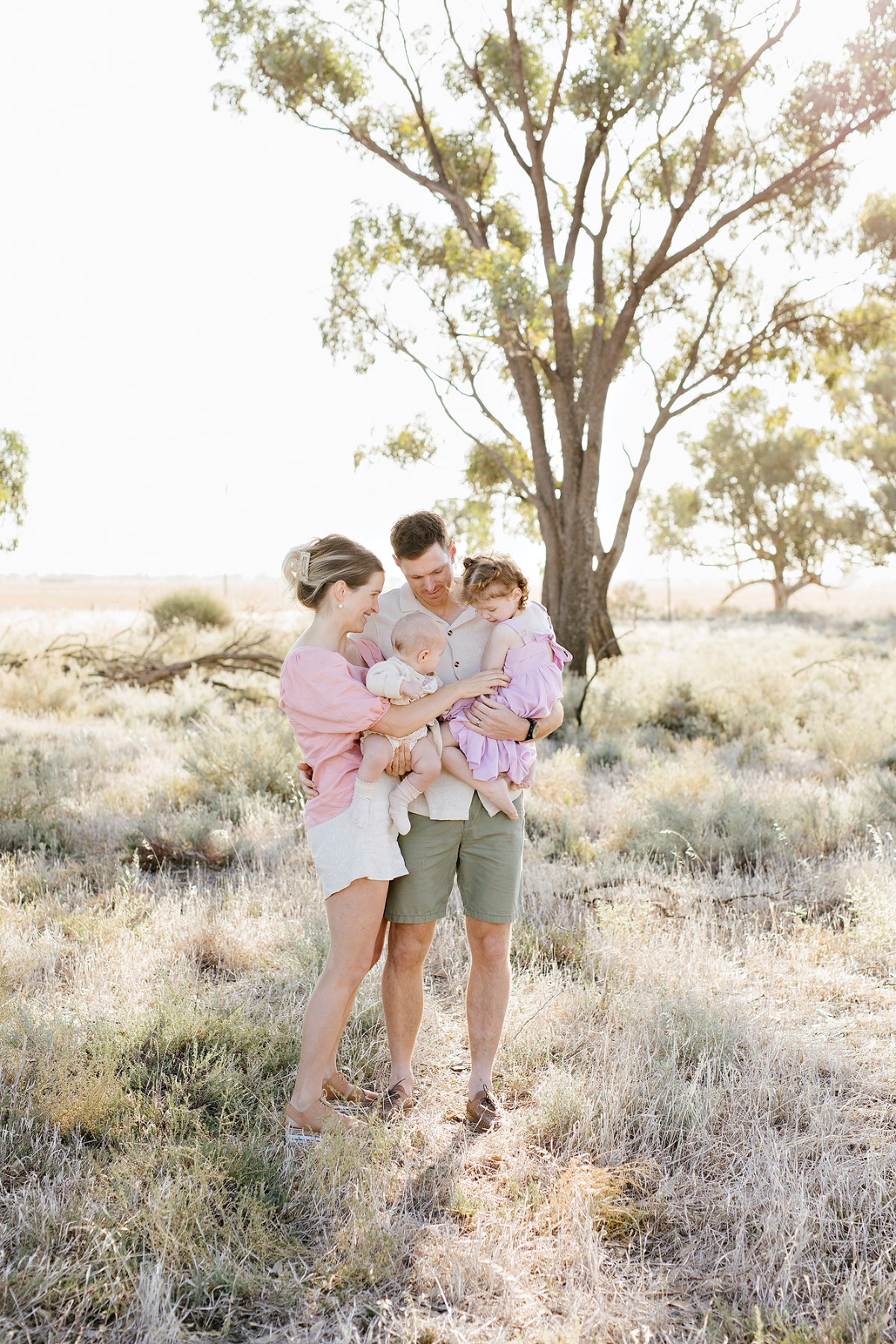 family standing in a field talking