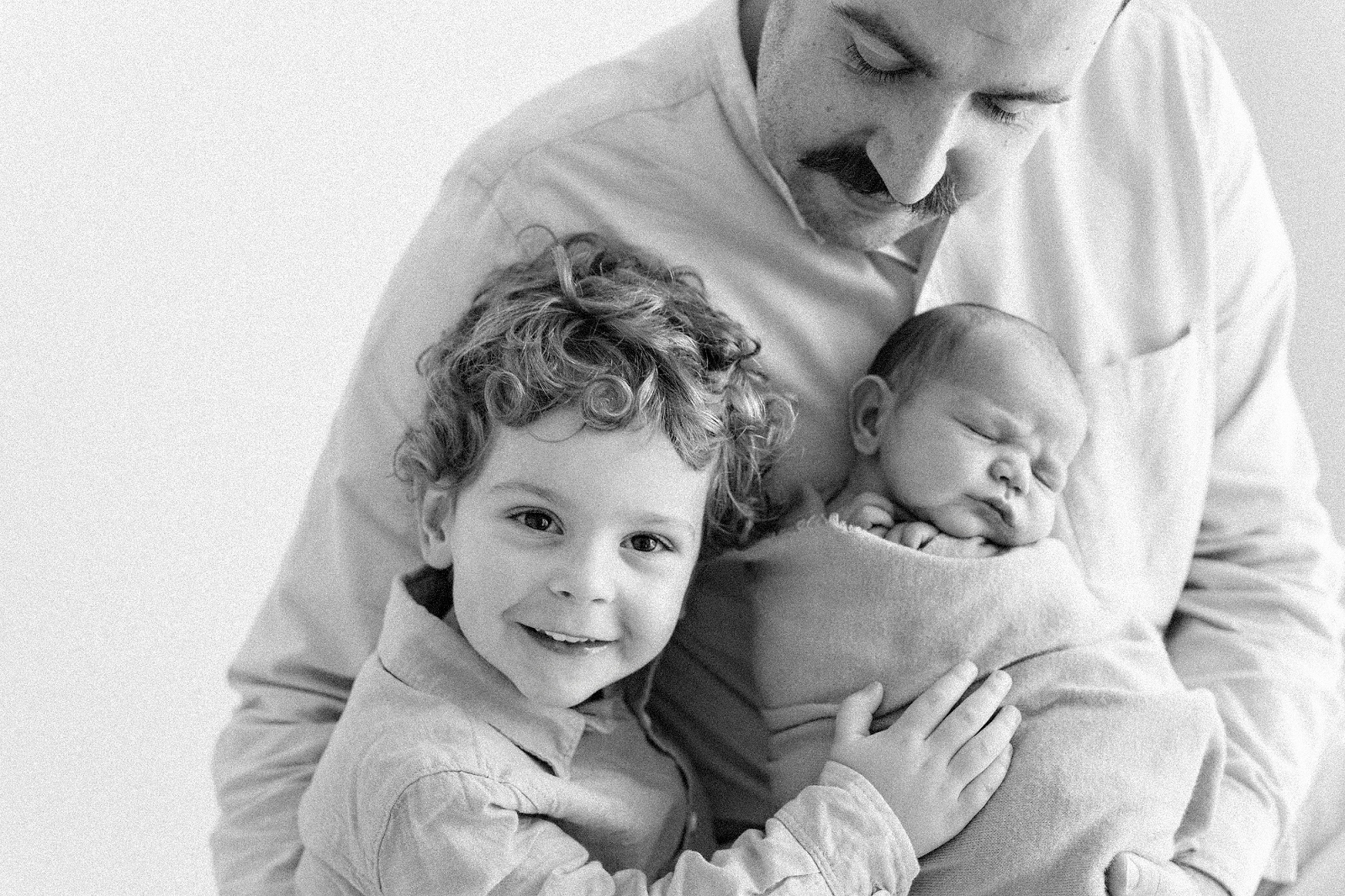 dad and toddler holding newborn baby