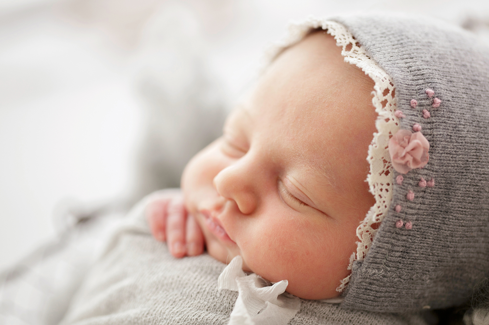 side profile of a baby with a grey bonnet